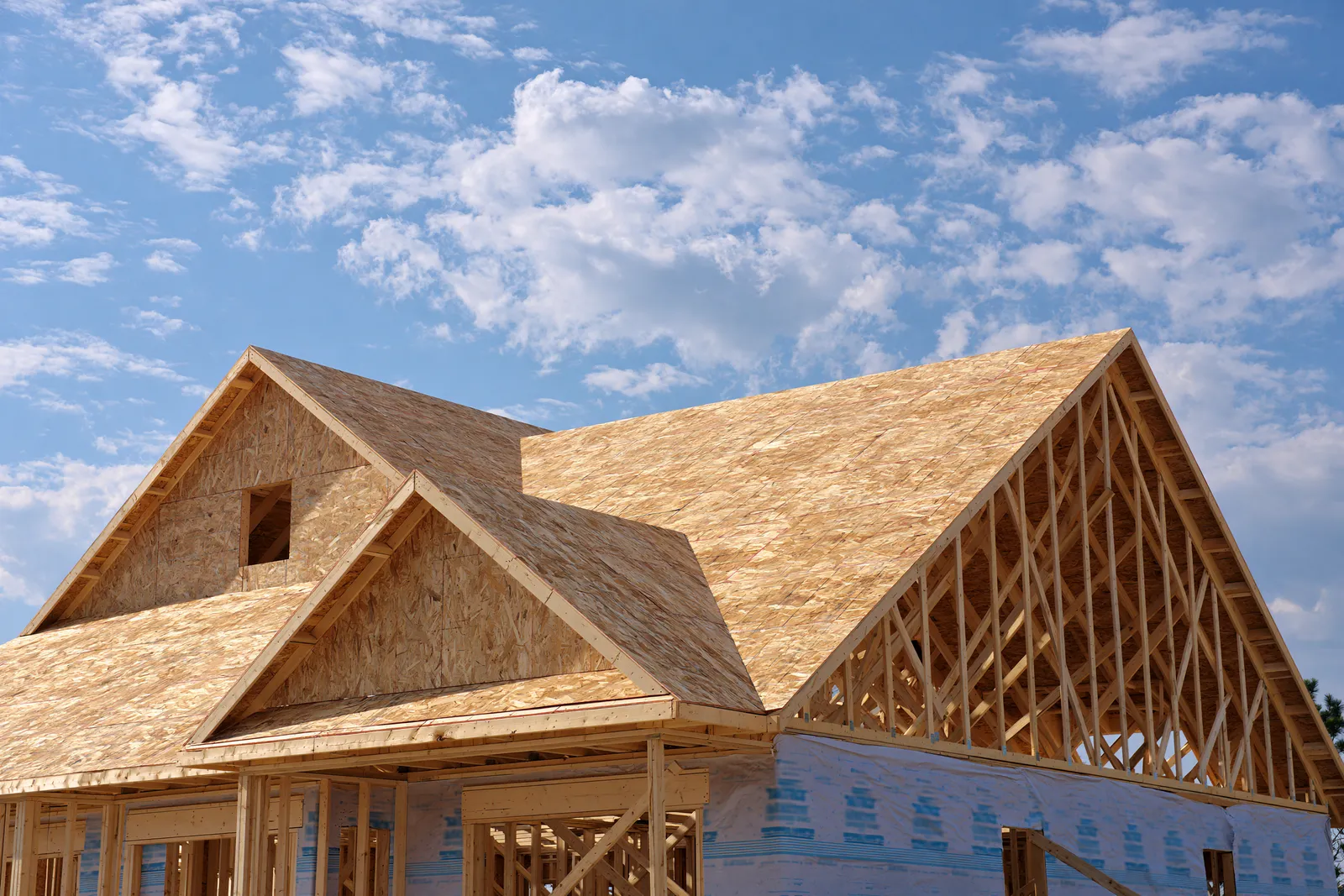A house under construction showing OSB decking and open roof trusses